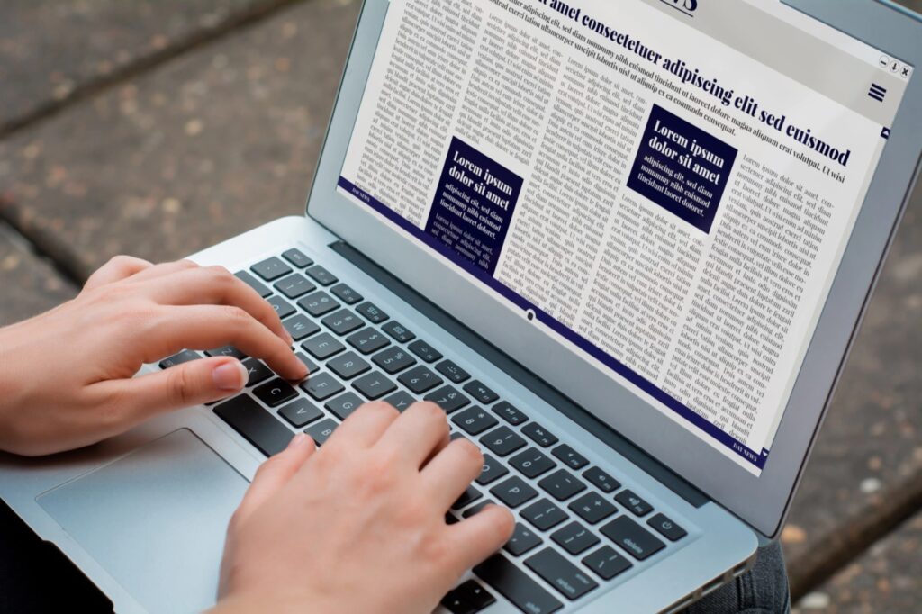 Person reading a local news article on a laptop, an example of earned media coverage